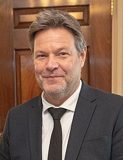 Robert Habeck, Bundesminister fr Wirtschaft und Klimaschutz, steht vor dem Weien Haus in Washington, D.C. – aufgenommen whrend eines offiziellen Besuchs im Jahr 2023. Er trgt einen dunklen Anzug und blickt ernst in die Kamera. Im Hintergrund sind die Sulen des historischen Gebudes zu erkennen.